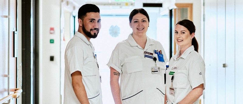 Bild på tre sjukvårdare i en korridor