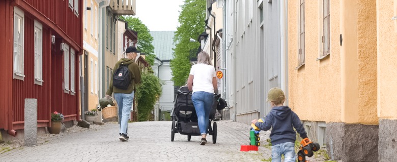 Barn och vuxna som går på en stenbelagd gata i Gamla stan i Eksjö.